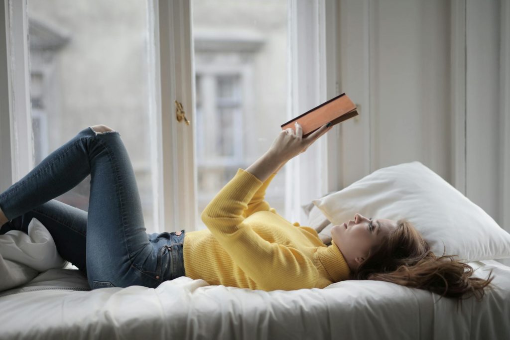 Ein Buch gemütlich im Bett lesen.